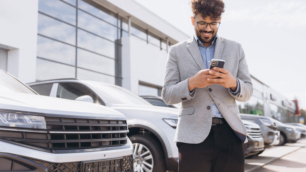 Personne consultant son smartphone pour réserver un parking près de sa voiture