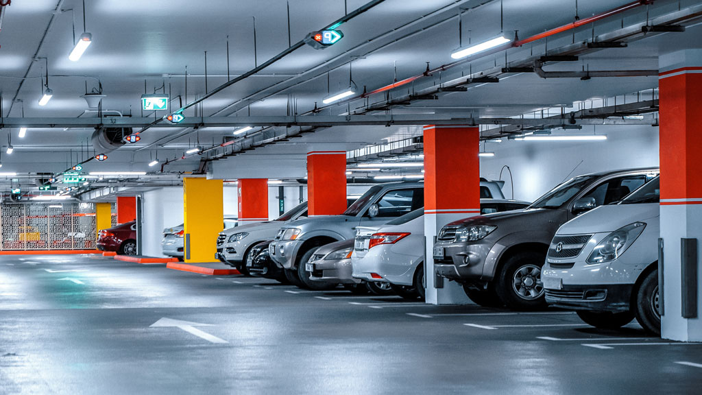 Parking extérieur aéroport Roissy avec véhicules stationnés en rangées